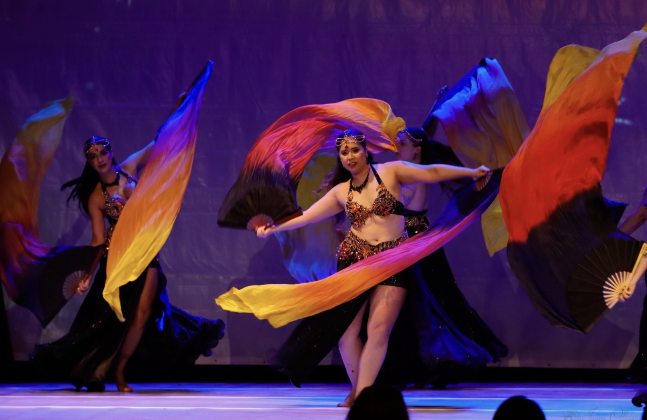 Dançarinas com leques coloridos na competição Bellyville